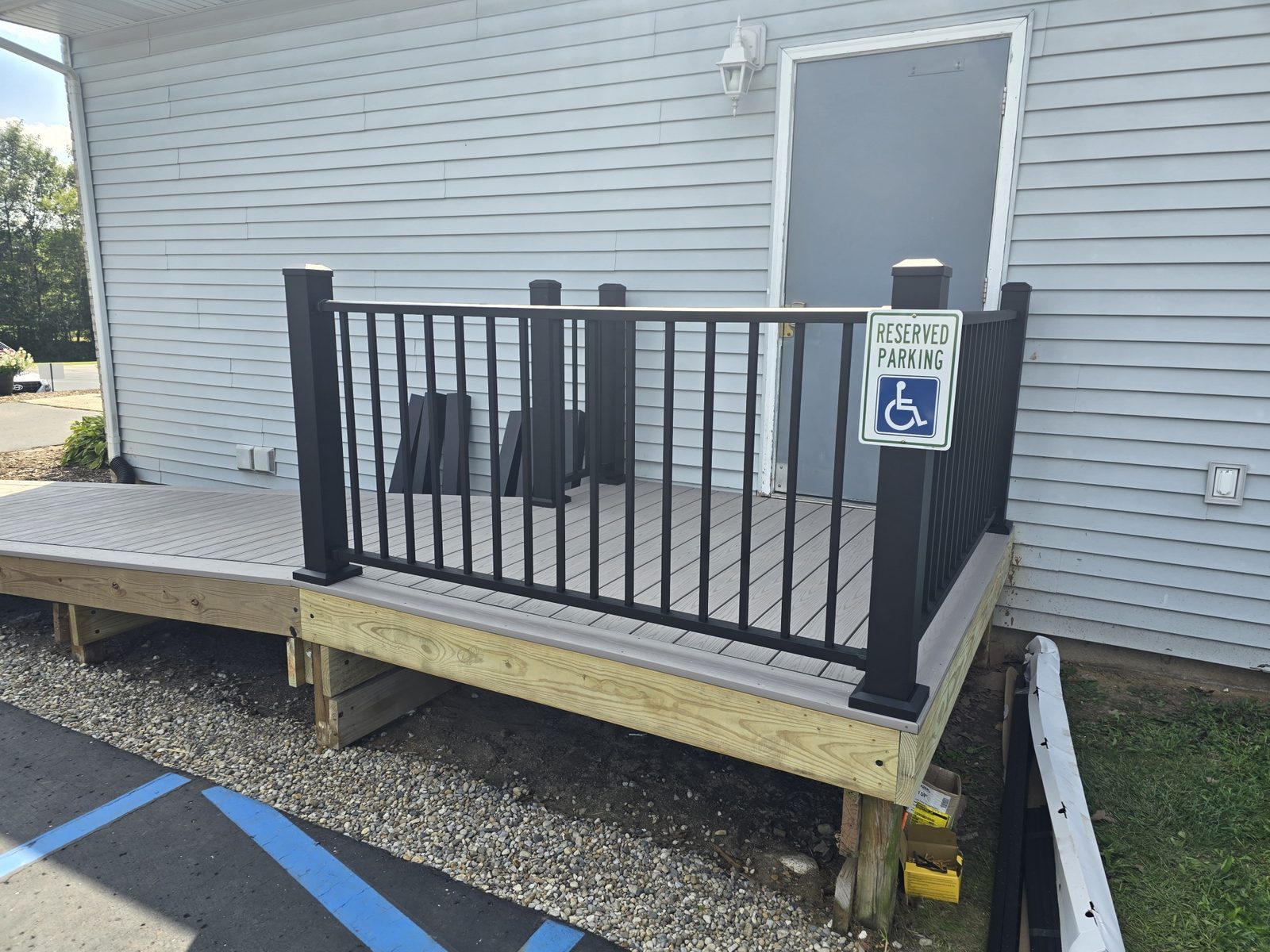 Composite landing with black aluminum railing at an accessible entry in Southwest Michigan