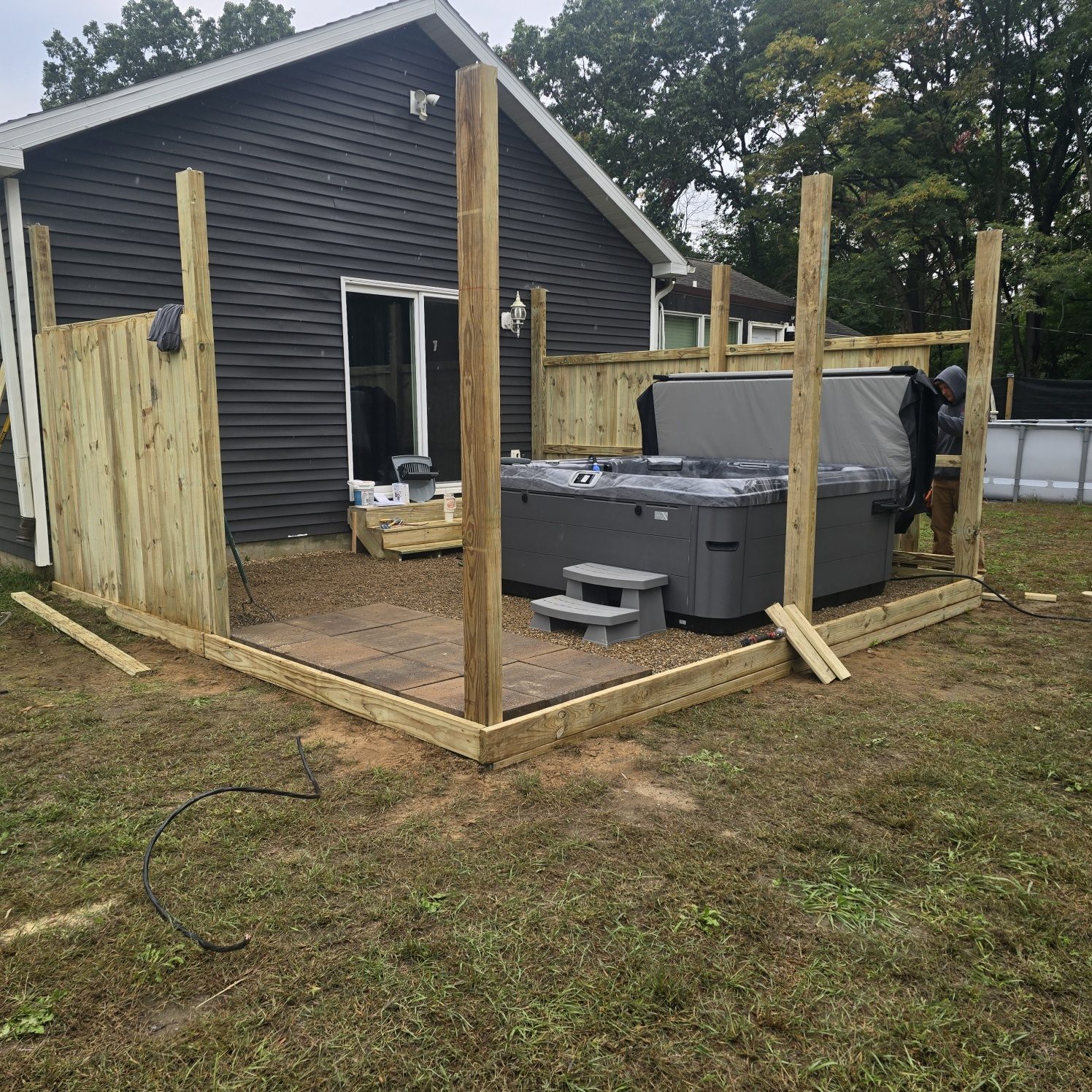 Hot tub set on a new gravel base while a wood privacy fence goes up around it in Southwest Michigan