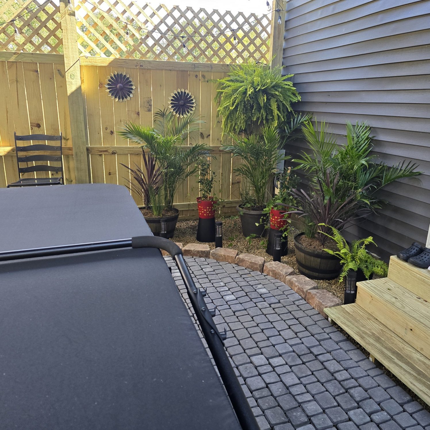 Finished backyard spa patio with potted plants, stone edging and steps to the house in Southwest Michigan