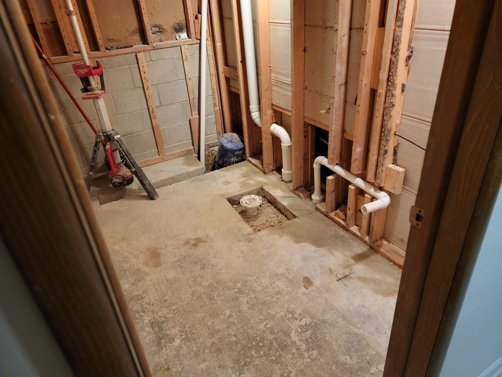 New shower drain set in the cut concrete floor of a basement bathroom remodel in Southwest Michigan