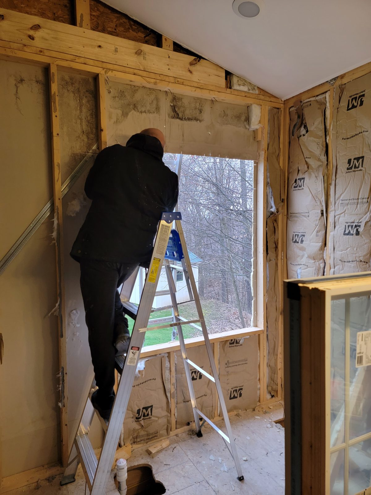 Old window being removed from a bathroom wall during a remodel in Southwest Michigan