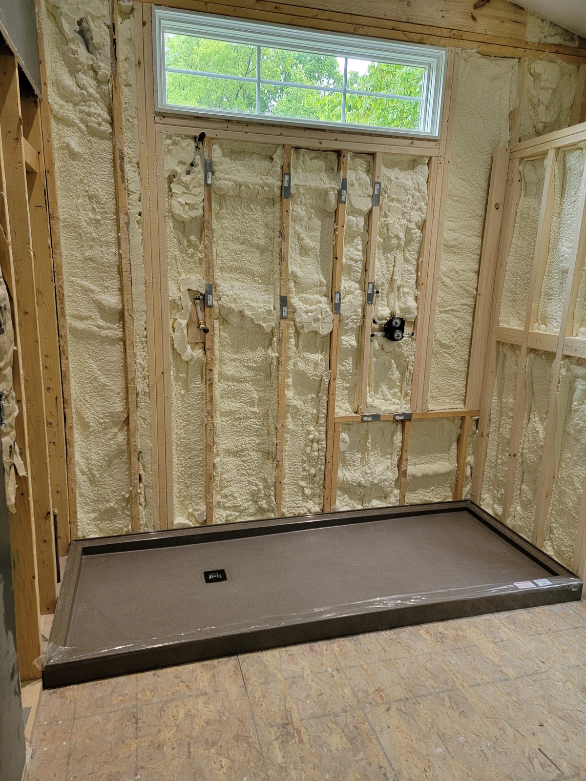 Large walk in shower base set against a spray foam insulated wall in Southwest Michigan