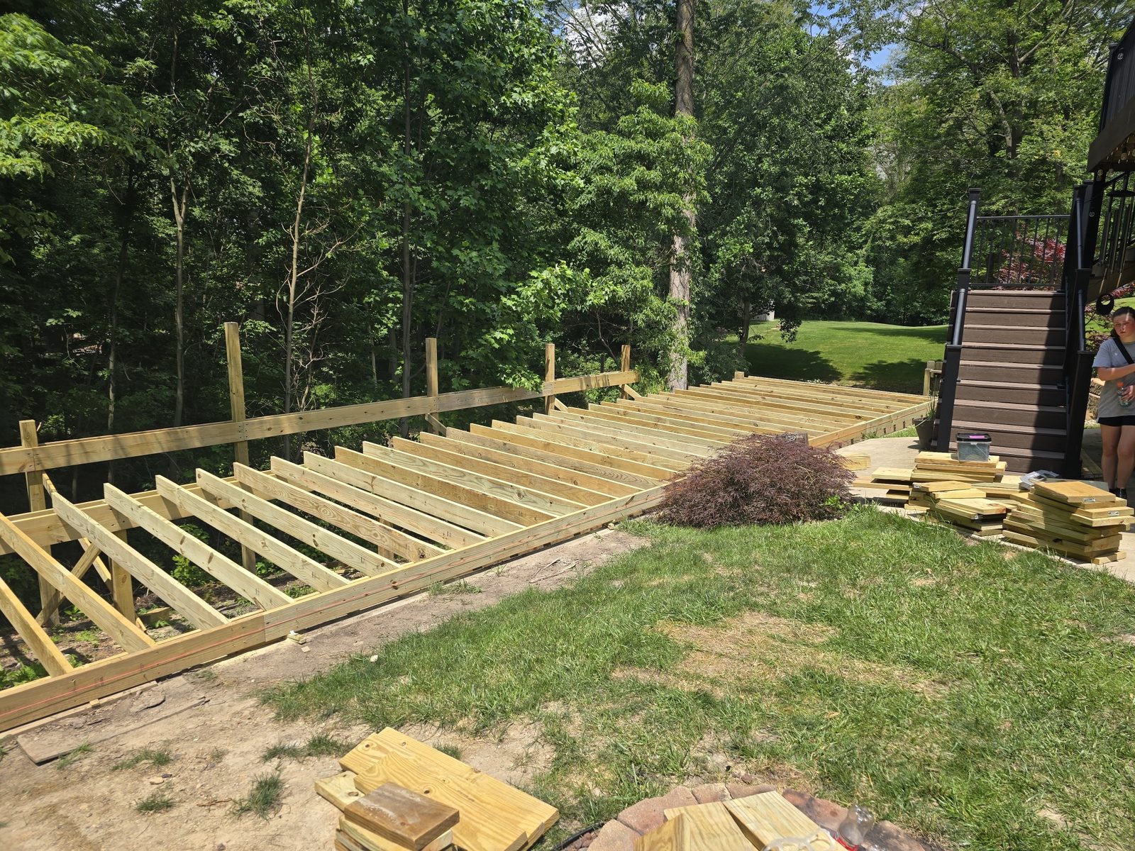 Ground level deck framing across a backyard in Southwest Michigan