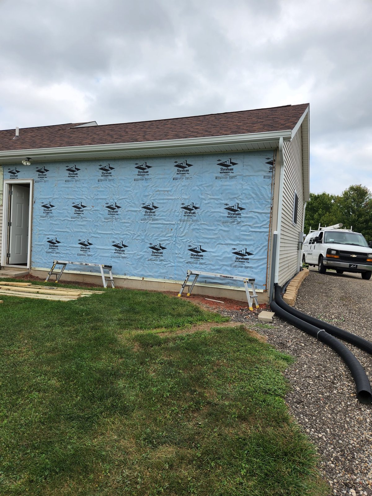 Side of a house wrapped in housewrap before a garage addition in Southwest Michigan