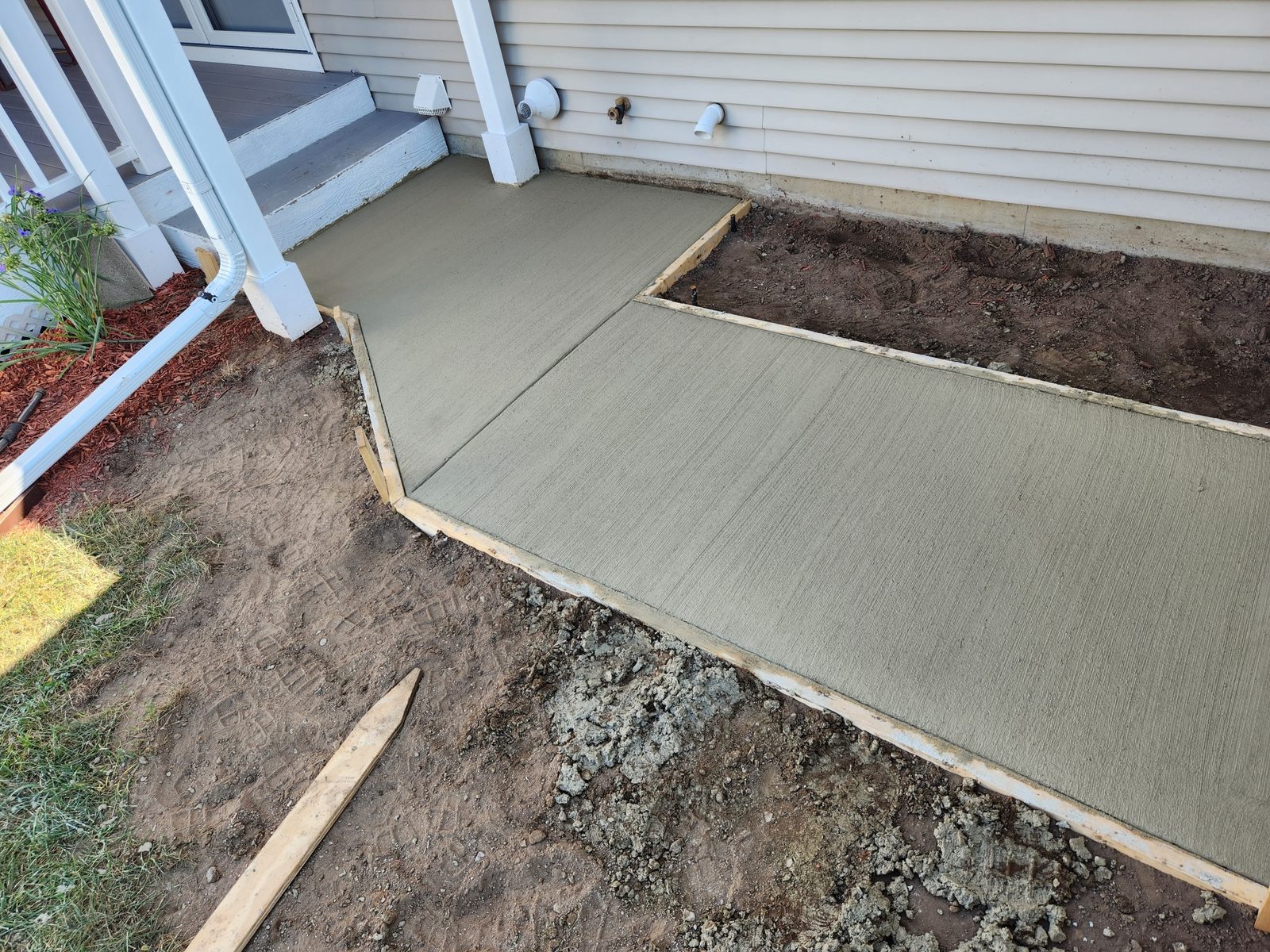 New concrete walkway poured along the side of a house in Southwest Michigan