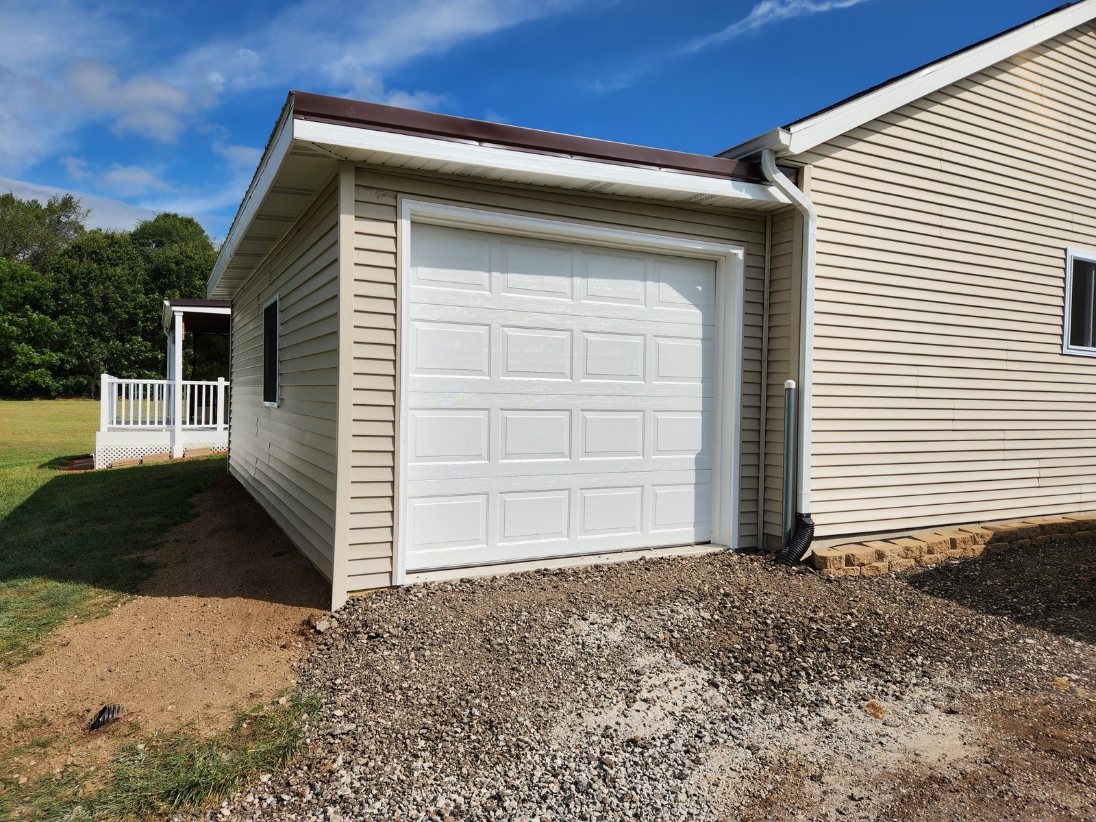 Finished single car garage addition with matching siding and a white overhead door in Southwest Michigan