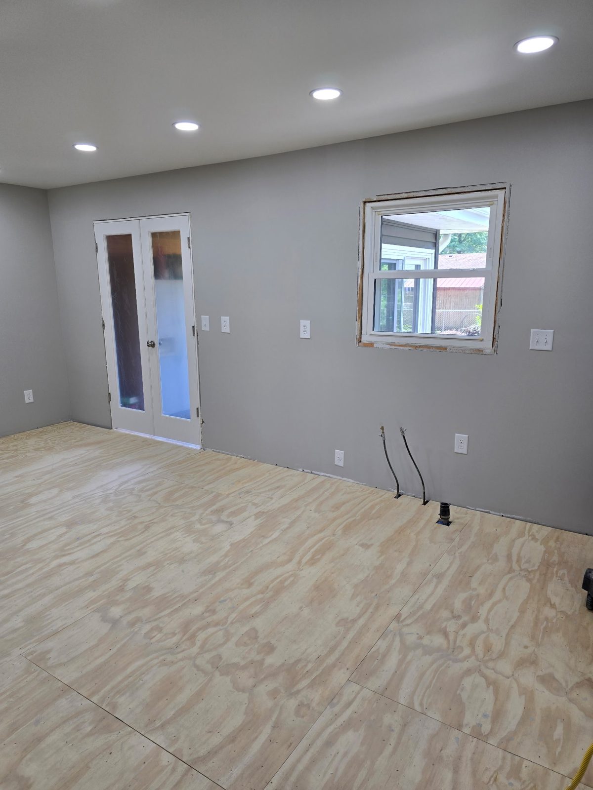 Kitchen painted soft gray with new recessed lighting and French doors during a remodel in Plainwell, MI