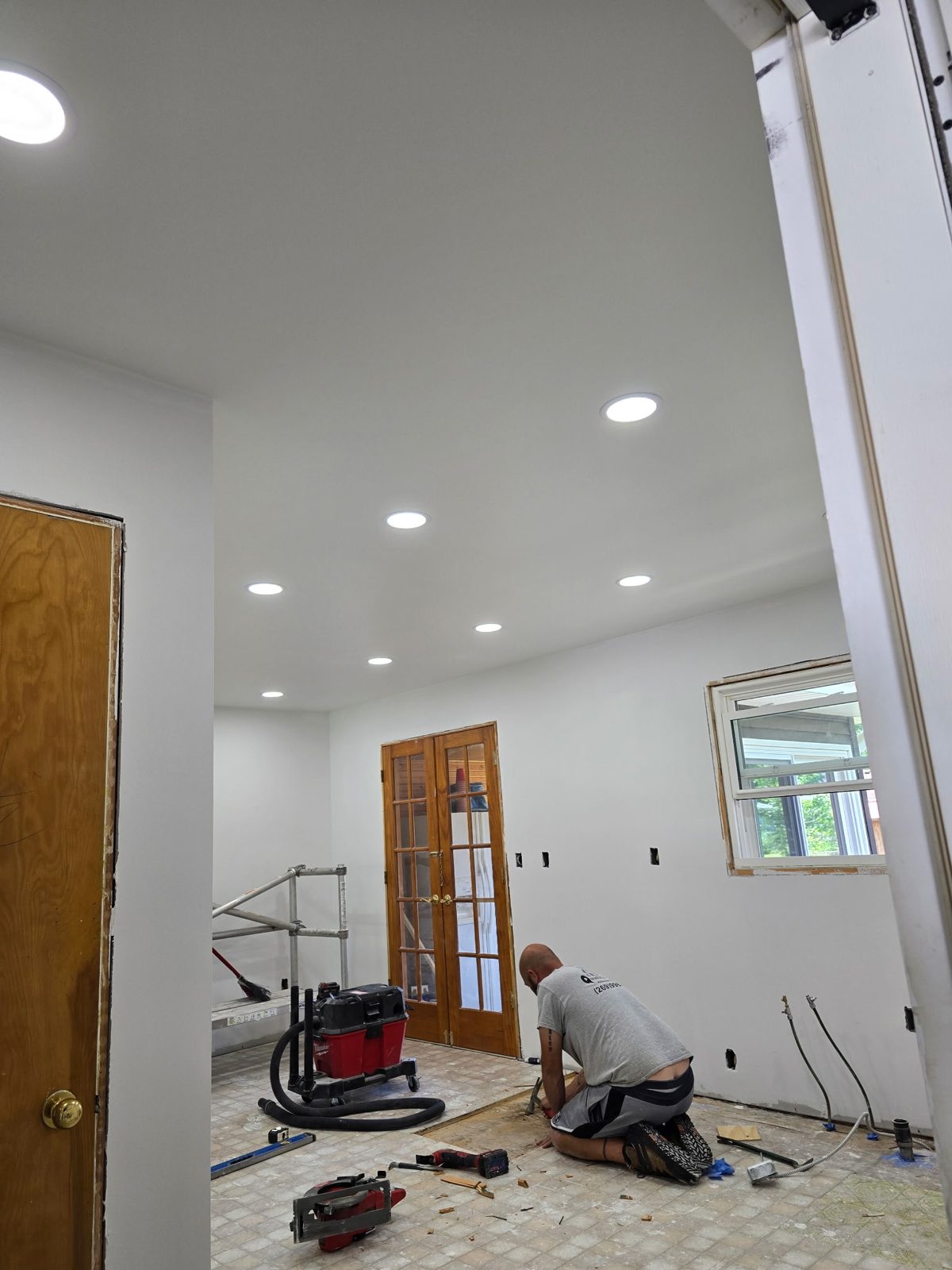 New recessed LED lighting installed while old kitchen flooring is removed during a remodel in Plainwell, MI