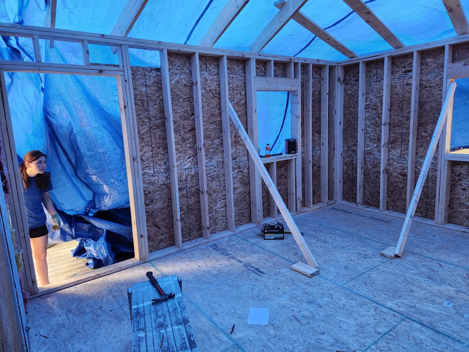 Inside the new framing of a rear addition in Southwest Michigan, covered with tarps against the weather
