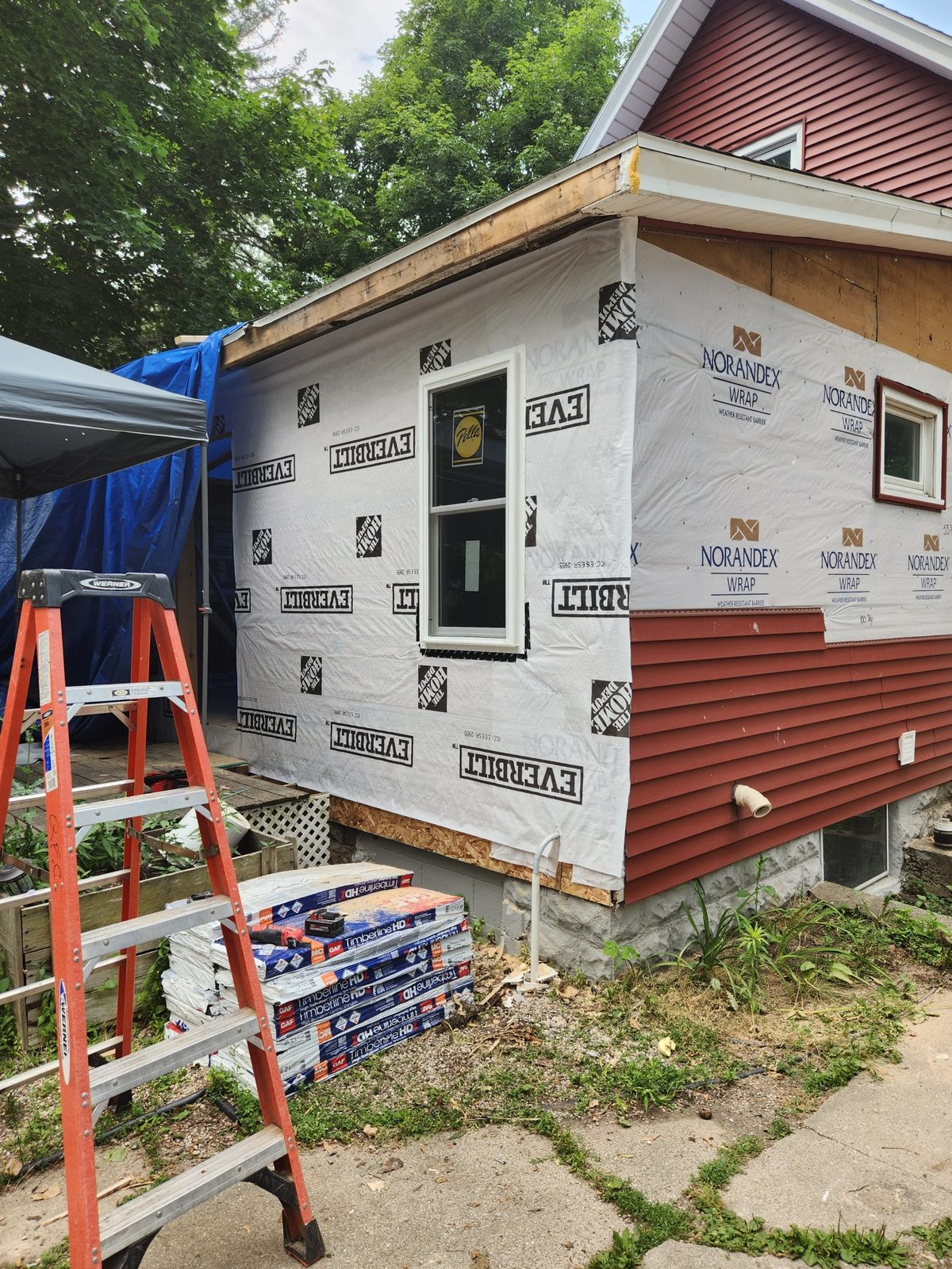 Housewrap and new windows on a rebuilt rear addition in Southwest Michigan, with red siding started