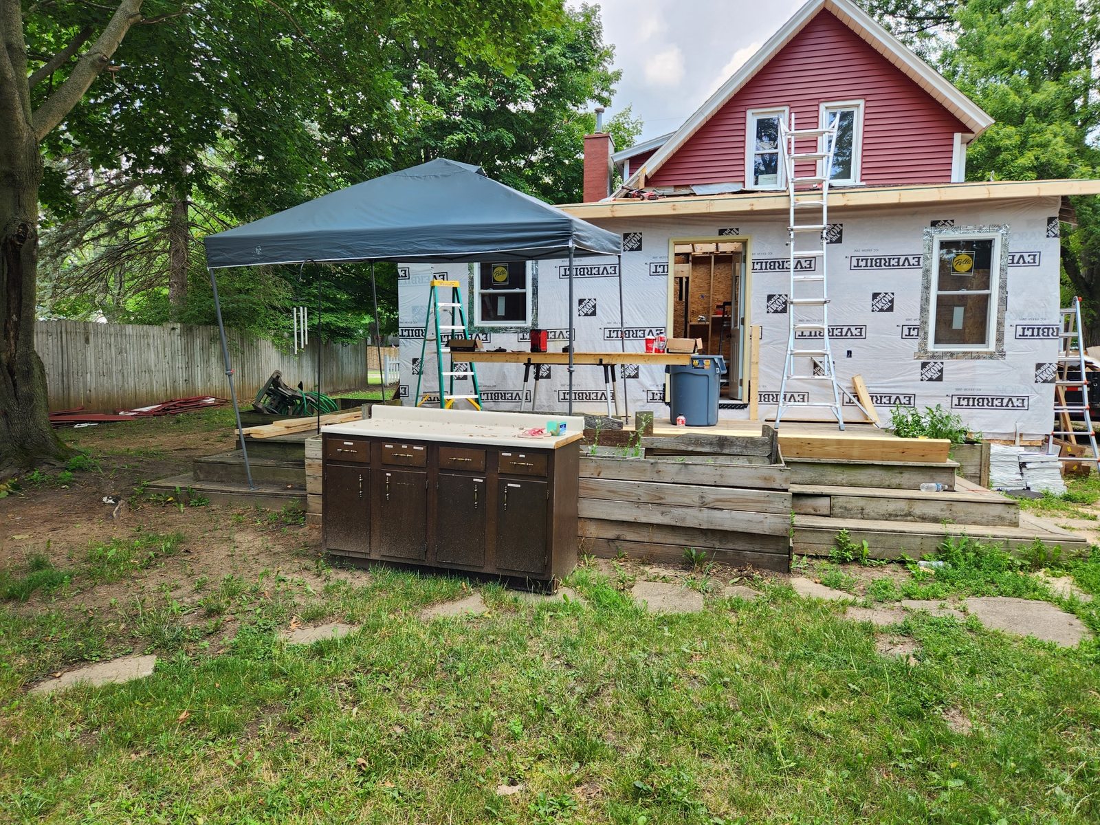 View from the yard of a rebuilt rear addition in housewrap in Southwest Michigan