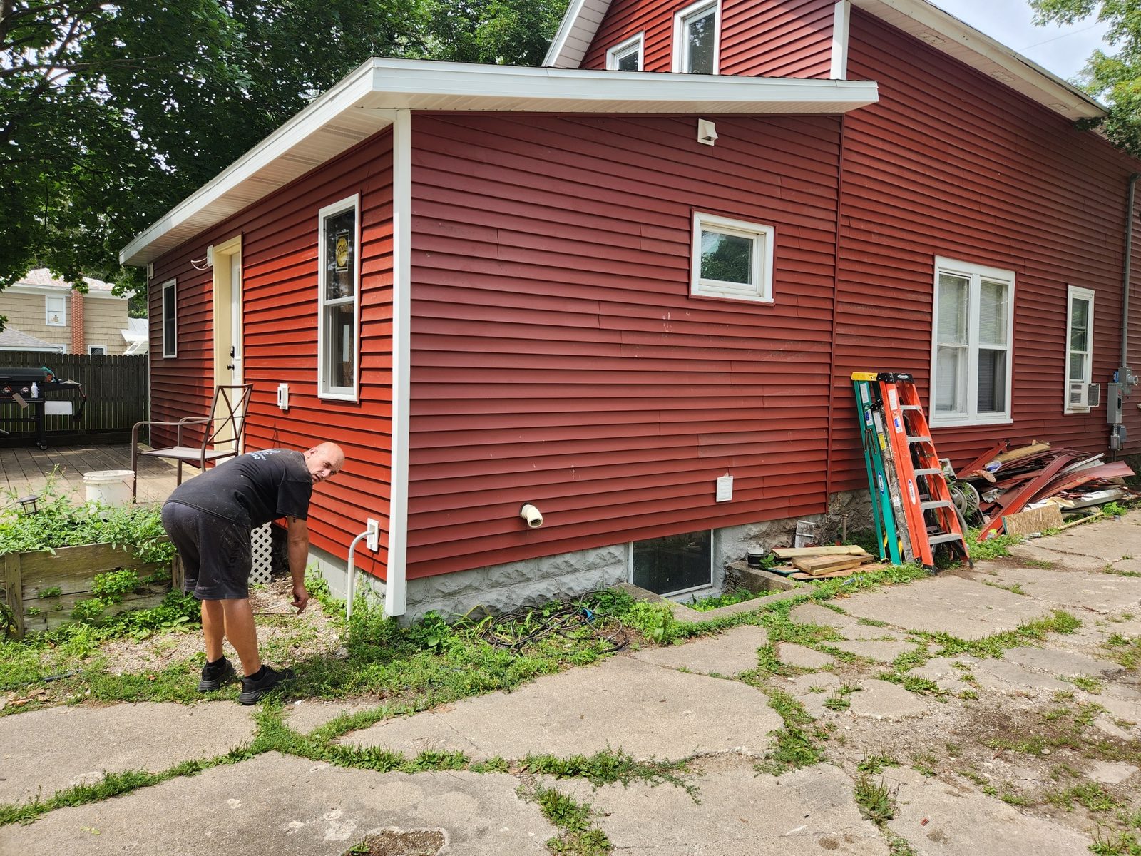 Side view of a rebuilt rear addition with red siding matched to the rest of the house in Southwest Michigan