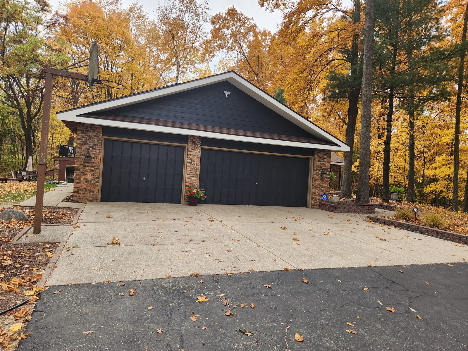 Finished garage in Southwest Michigan with deep navy siding, white trim and black garage doors