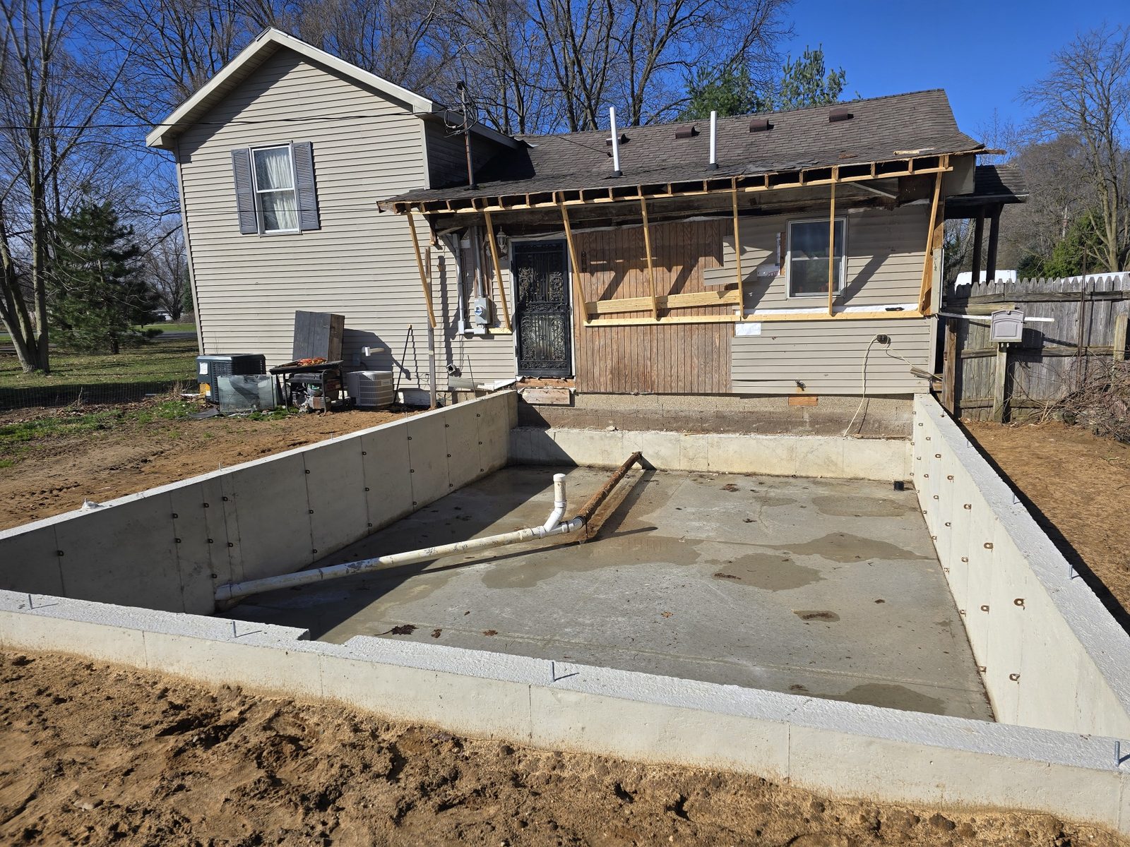 Poured concrete foundation walls for a room addition behind a home in Southwest Michigan