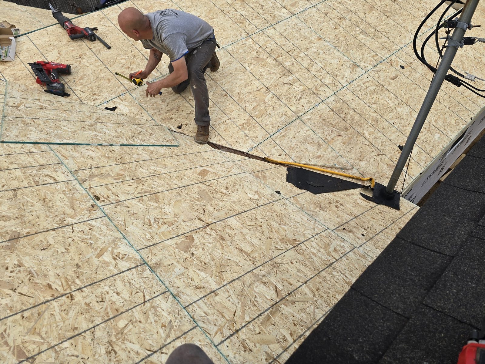 Quality Finish crew nailing down roof sheathing on a room addition in Southwest Michigan