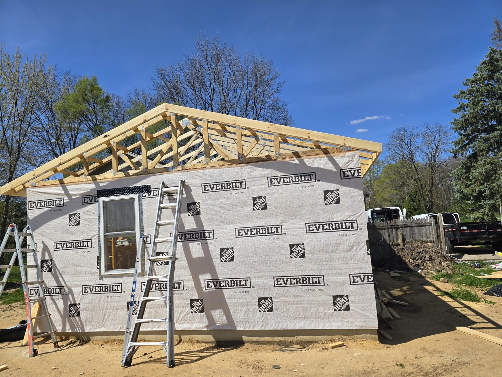 Roof trusses set and housewrap installed on a room addition in Southwest Michigan