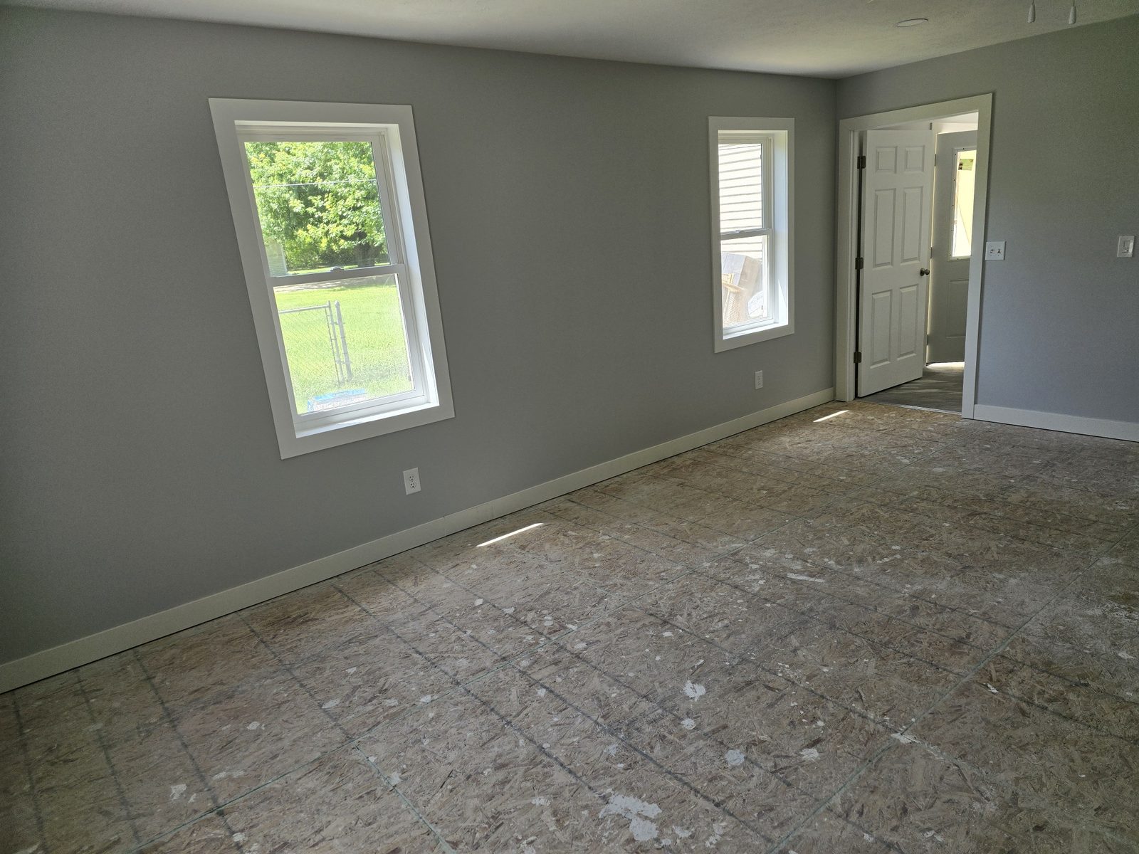 Finished room addition interior in Southwest Michigan with gray walls, white trim and three windows
